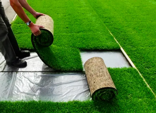 jardinero instalando césped artificial